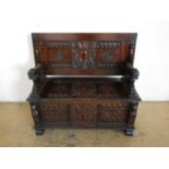 An old reproduction carved oak monks' bench