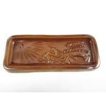 A Second World War ceramic pen tray depicting in relief a dragon impaled by a spear under a