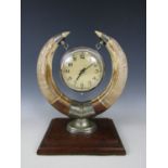 A 1930s-1940s clock, supported within two large warthog tusks, the latter having nickel plated