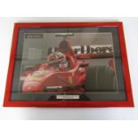 A framed magazine centrefold featuring Michael Schumacher in his Formula 1 Ferrari at Silverstone