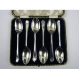 A cased set of six George V silver tea spoons, each having a crossed golf clubs device facing its