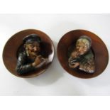 A pair of late 19th / early 20th Century continental European tobacconists' wall plaques, modelled