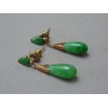 A pair of 1930s jade pendant earrings, each having a pear-shaped cabochon stud earring above a