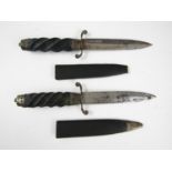 A pair of late 19th / early 20th Century daggers, each having spirally fluted grip, re-curved