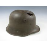 A shrapnel damaged Imperial German M' 1916 steel helmet
