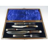 An Edwardian silver-mounted and antler-handled carving set, comprising two knives, two carving forks