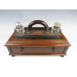 A Victorian ebonised mahogany ink standish, with cut glass ink wells, pen trays and single frieze