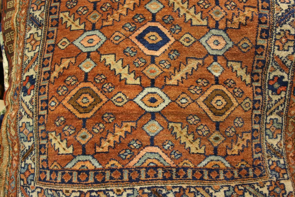 Kurdish rug with all-over geometric design on a salmon ground with borders,