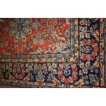 Large Persian style carpet having all-over floral design on a rust and blue ground with multiple