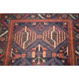 Kurdish rug having all-over floral and geometric design with multiple borders on a dark blue ground,