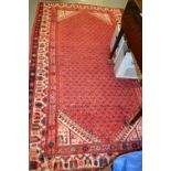Serabend rug with all-over Boteh design on a red ground with borders,