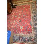 Persian design rug with all-over floral pattern on a red ground with borders,