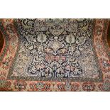 Small silk style rug of Kashan design with medallion and all-over floral design on a blue ground