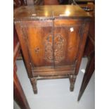 20th Century oak side cabinet having hinged cover above two flush panelled doors with floral carved