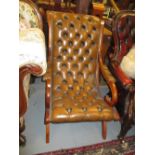 Reproduction mahogany and buttoned leather upholstered open armchair on sabre legs