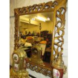 Carved and gilded cushion frame wall mirror with pierced border