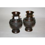 Pair of early 20th Century Chinese bronze baluster form vases with dragon decoration on a mottled
