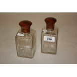 Two Edwardian circular glass dressing table jars with silver mounted tortoiseshell covers