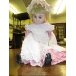 Wax headed doll with fixed eyes and closed mouth on a jointed composition body
