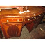 Late George III mahogany crossbanded and line inlaid serpentine shaped sideboard with a central