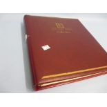 Red stamp album containing a collection of Q.E.