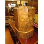 Art Deco burr walnut octagonal smokers cabinet having hinged cover and various drawers and doors