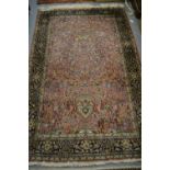 Qum rug with vase and all-over floral and bird design on a pink ground with borders,