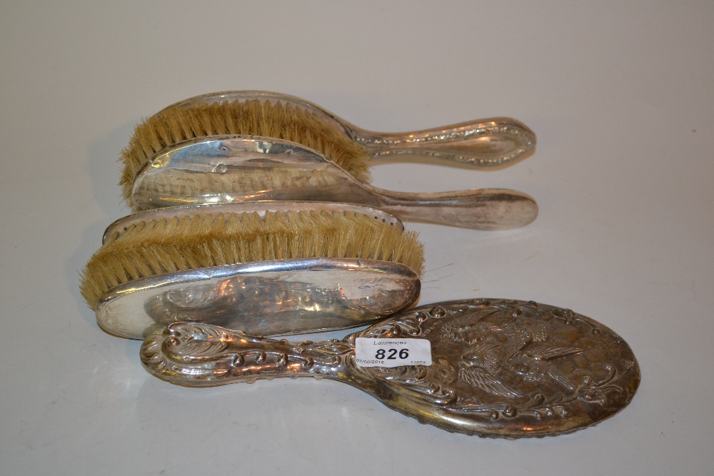 Four silver mounted brushes and a silver mounted hand mirror