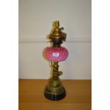 Brass oil lamp with pink glass well adapted for use with electricity