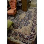 Small Kirman carpet with a medallion and all-over floral design on a blue ground with borders,