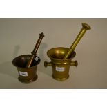 Antique bell metal pestle and mortar together with a similar brass pestle and mortar