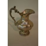 Large Continental white metal jug having C scroll handle on circular floral decorated foot
