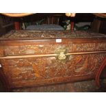 Oriental carved camphor wood trunk with brass clasp on low supports