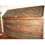 George III carved oak bureau with a fall front above four graduated drawers on bracket supports