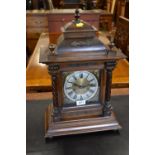 Late 19th Century Continental walnut mantel clock with a dome top above a square door flanked by