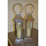 Pair of modern chrome square garden lanterns with candles