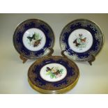 Set of eight Caverswall plates decorated with butterflies within a cobalt blue and gilt border