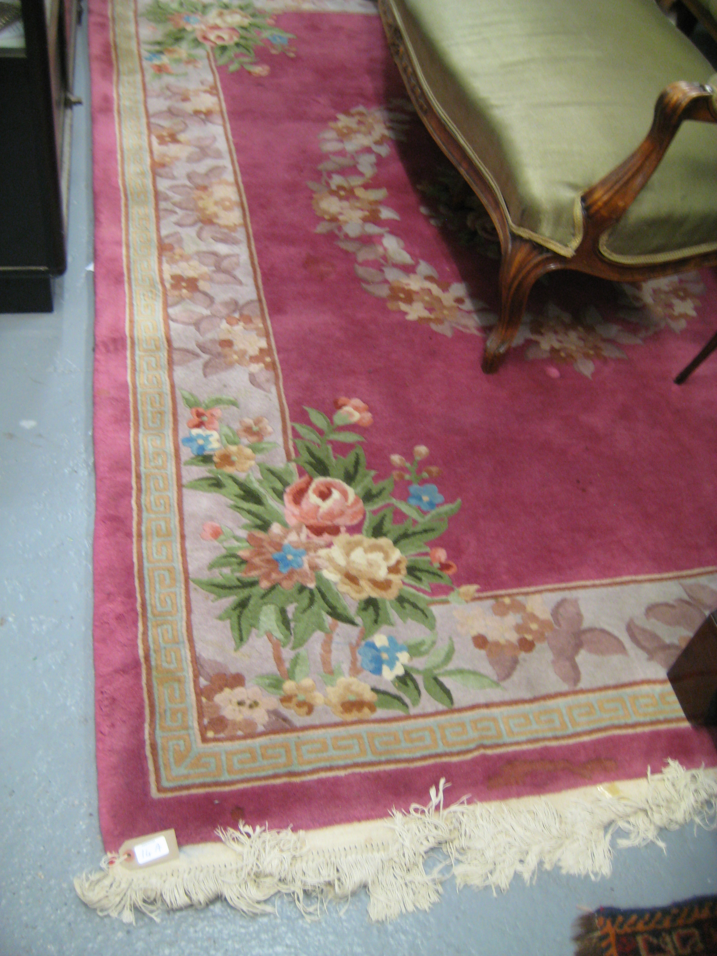 Chinese woollen carpet with floral design on a pink ground together with an Indian oval woollen