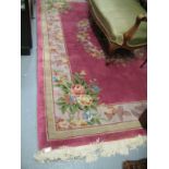 Chinese woollen carpet with floral design on a pink ground together with an Indian oval woollen