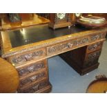 19th Century oak twin pedestal desk with nine carved mask head drawers