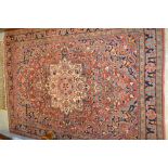 Saruq rug with a centre medallion and all-over floral design and multiple borders on a red ground,