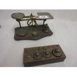 Pair of small brass postal scales on mahogany base with a set of weights