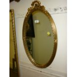 Oval gilt framed wall mirror with bow surmount