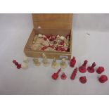Box containing a quantity of various red stained bone and natural chess pieces