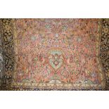 Qum rug with vase and all-over floral and bird design on a pink ground with borders,