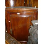 George III mahogany hanging corner cupboard with a single panel door,