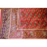 Machine made Bokhara pattern rug on red ground, 1.9m x 1.