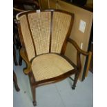 Early 20th Century beechwood wing armchair with cane back and seat