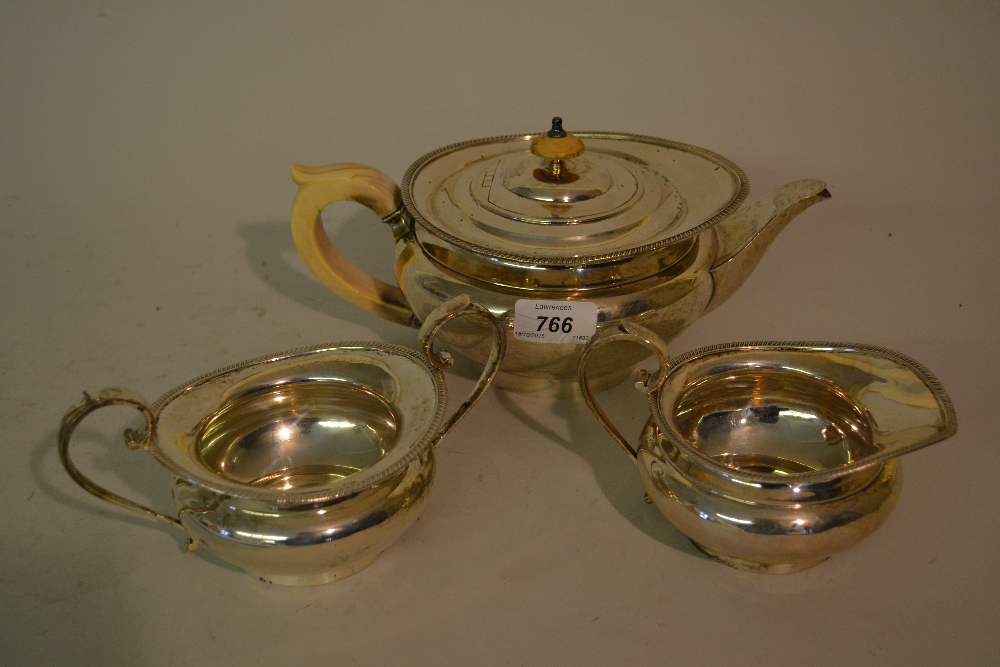Silver three piece tea service of squat circular baluster form with gadroon edges,