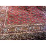 Machine made Bokhara pattern rug on red ground, 1.9m x 1.